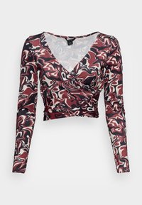 Blusa de manga longa envolvente com um padrão abstrato em vermelho, preto e creme. Apresenta um decote V profundo e uma silhueta ajustada. Tecido macio e elástico.