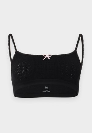 Musta neulottu bralette, jossa ohut aaltoileva olkaimet ja pieni vaalea vaaleanpunainen rusetti keskellä yläreunassa edessä.