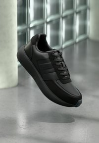 Μαύρο δερμάτινο αθλητικό παπούτσι με υφασμάτινες λεπτομέρειες, σχέδιο με κορδόνια, στρογγυλή μύτη και καουτσούκ σόλα με αντίθεση μπλε λεπτομέρειες.