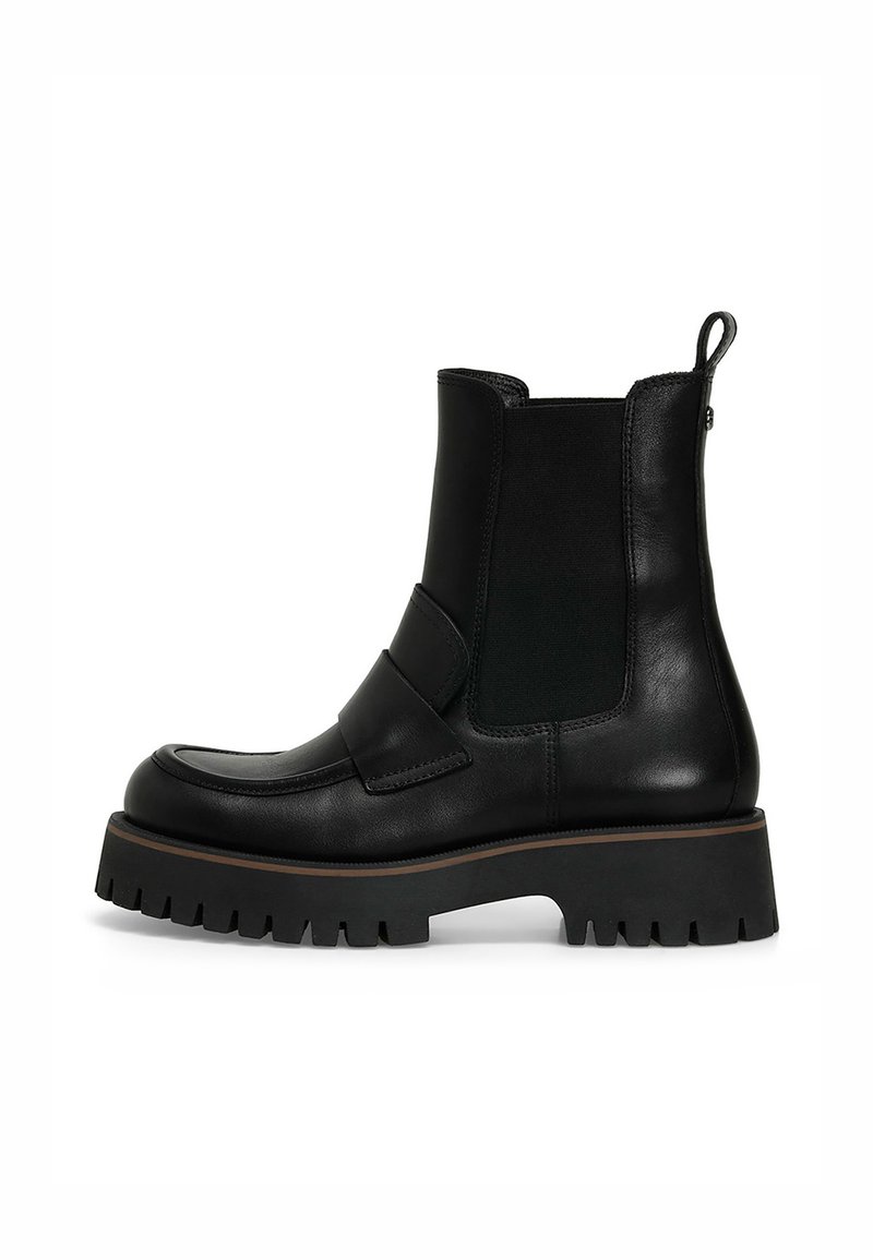 Botas de tobillo de cuero negro con paneles elásticos en los laterales, suela de goma gruesa y una lengüeta en la parte posterior. Base gruesa con textura estriada.