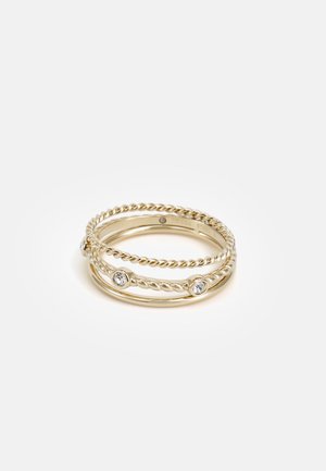 Bague empilables de couleur or avec des designs torsadés et de petites pierres précieuses claires serties dans l'anneau. Surfaces lisses et texturées.