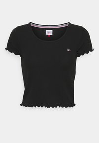 Top corto nero a costine con maniche corte, caratterizzato da bordi a scallop e un piccolo logo sul petto. Dettaglio a righe all'interno dello scollo.