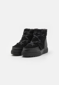 Botas de tobillo negras hechas de ante y materiales sintéticos, con ribete de piel de pelo, suelas texturizadas y diseño de cordones con acentos metálicos.