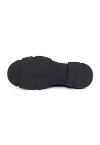 Talpa de pantof din cauciuc negru, cu modele geometrice de tracțiune și suprafață texturată, prezentată din partea de jos pe un fundal alb.