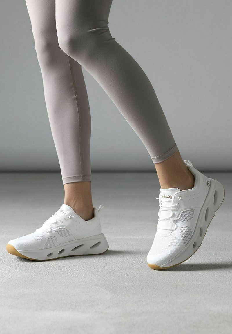 Weiße Sportschuhe mit Mesh-Obermaterial, gepolstertem Knöchelbereich und Gummisohle. Mit durchbrochenen Akzenten und einfarbigen Schnürsenkeln.