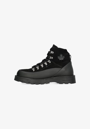 Schwarze Wanderschuhe aus Wildleder und Gummi, mit Metallösen, einer strukturierten Sohle und einem Ahornblatt-Logo an der Seite.