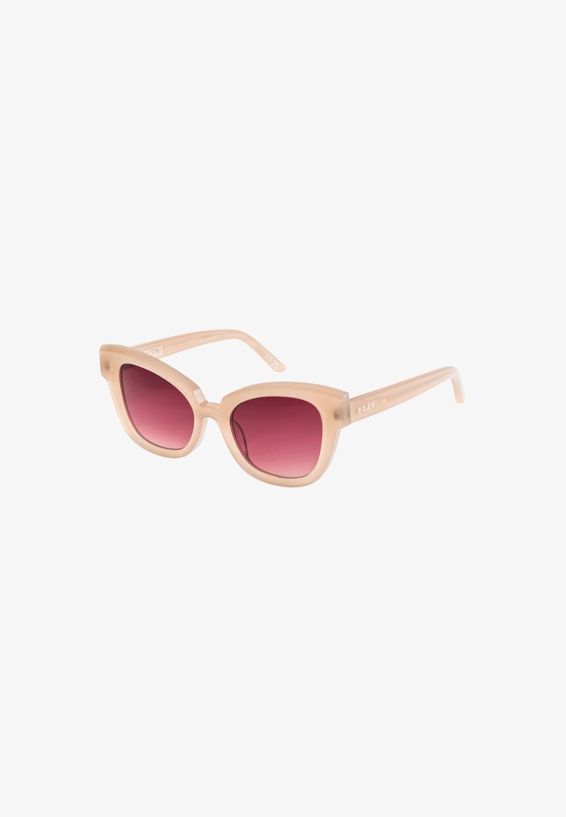 Cat-eye sunglasses with a translucent nude frame and gradient pink lenses. Lightweight plastic design with Roxy branding on the temples.