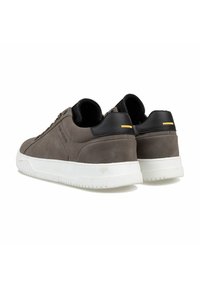 Graue Wildledersneaker mit schwarzen Lederakzenten, weißen Gummisohlen und einem gelben Detail an der Ferse. Niedrig geschnittenes Design mit runder Zehenform.
