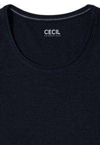 Haut bleu marine avec encolure ronde et "CECIL ESSENTIALS" imprimé à l'intérieur du col en blanc.