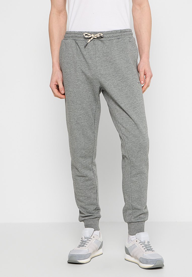 Grijze sweatpants van een zachte katoenmix, met een trekkoord in de taille en geribbelde manchetten, gecombineerd met lichtgrijze sneakers.