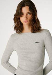 Top cinza de mangas longas feito de tecido canelado, apresentando um decote redondo e um pequeno logótipo preto "Pepe Jeans" no peito.