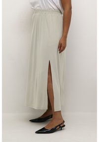 Light grey midi skirt with an elastic waistband and a side slit, paired with black pointed-toe slingback shoes. Smooth texture.