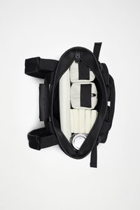 Czarna torba z zamkiem błyskawicznym, z jasnymi przegródkami do przechowywania, cylindryczną puszką i miękkimi, wyściełanymi elementami organizacyjnymi w środku.