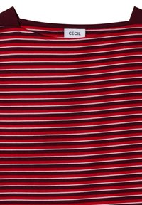 Gros plan sur le col d’un t-shirt à rayures horizontales grenat, rouges et blanches avec une étiquette blanche portant la mention "CECIL."