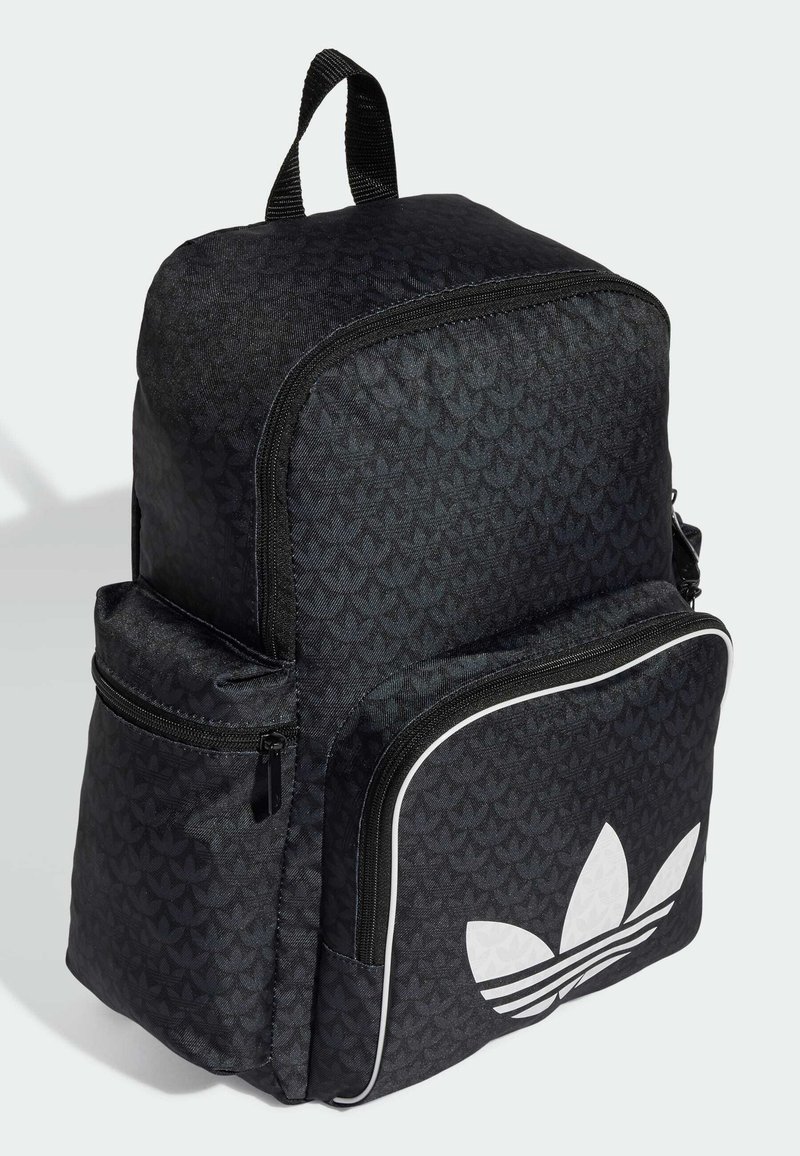 Mochila de tela negra con un patrón texturizado, forma estructurada, bolsillo frontal con cremallera y acentos de logo blanco, y asa duradera.