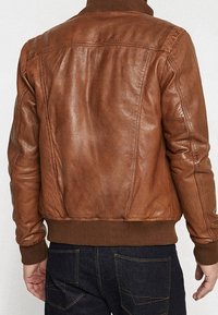 Brown leather bomber jacket featuring a ribbed collar and cuffs, smooth texture, and detailed stitching along the seams.