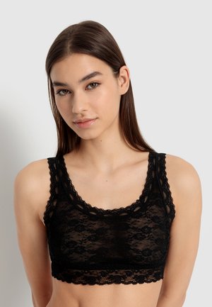 Black lace bralette featuring a floral pattern, scalloped edges, and a low neckline. Soft, sheer material with wide straps.