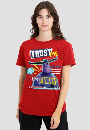 Red cotton T-shirt featuring a graphic design with a purple character and text: "TRUST ME HA HA I'M FUNNY" with colorful accents.