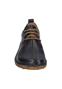Scarpe stringate in pelle nera con finitura liscia, lacci marroni a contrasto, cuciture beige e suola marrone testurizzata.