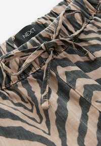 Beige en zwarte zebra print broek met elastische tailleband en een gestrikt koord, met een klein zwart NEXT merklabel.