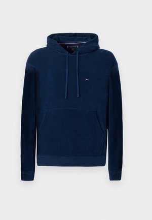 Navy blue hooded sweatshirt, soft fleece material, front kangaroo pocket, ribbed cuffs, small logo on chest, relaxed fit design.
