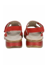 Sandali rossi in suede con cinturini regolabili, dotati di una suola piatta e testurizzata. Design con retro aperto, insole liscia e struttura di sostegno.