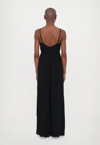 Black sleeveless jumpsuit with a fitted waist and wide-leg silhouette. Features thin adjustable straps and a smooth fabric texture.
