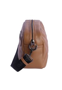 Bolso de cuero sintético color beige con textura acolchada, cierre con cremallera plateada y correa negra ajustable. Forma rectangular redondeada.