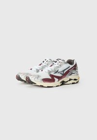 Mesh running shoes in white with maroon accents. Features a textured upper, gray logo, thick sole with black and yellow details.