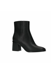 Bottines noires en cuir lisse, ornées d'un talon carré et d'une pointe effilée. La semelle est noire avec un profil minimal.