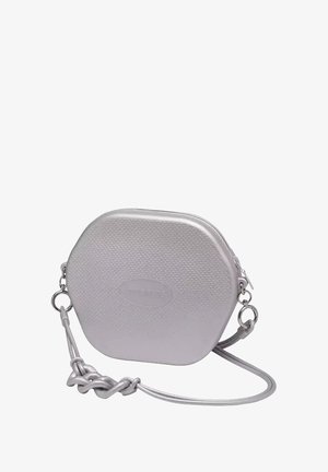 Borsa esagonale in argento con esterno testurizzato, chiusura a zip e tracolla staccabile con un accento intrecciato. Dettagli in hardware argentato.