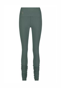 Högmidjade mörkgröna leggings med rynkade detaljer vid anklarna och en liten broderad logotyp nära midjan.