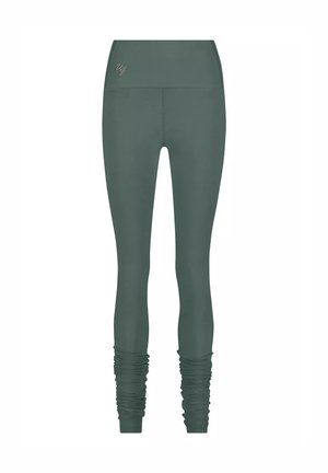 Tummanvihreät korkeavyötäröiset leggingit, joissa on rypytetty yksityiskohta nilkoissa ja pieni brodeerattu logo vyötärön lähellä.