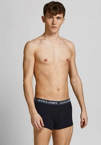 Sorte boxershorts med en grå linning, der har "JACK & JONES"-mærkning. Stoffet ser glat ud med et tætsiddende design.