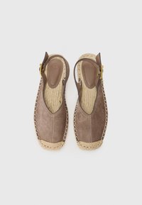 Sandale slingback din suede maro cu o talpă espadrille împletită și detalii de cusătură contrastante. Au o cataramă ajustabilă de culoare aurie.