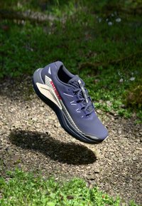 Marineblaue Laufschuhe mit einem atmungsaktiven Obermaterial, texturierten Zwischensohlen und weißen Akzenten. Sie verfügen über eine abgerundete Zehenpartie und ein leichtes Design. Schweben über dem Boden.