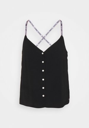 Czarna bluzka bez rękawów z białymi guzikami z przodu oraz skrzyżowanymi białymi paskami oznaczonymi "Tommy Jeans" na jednolitym tle.