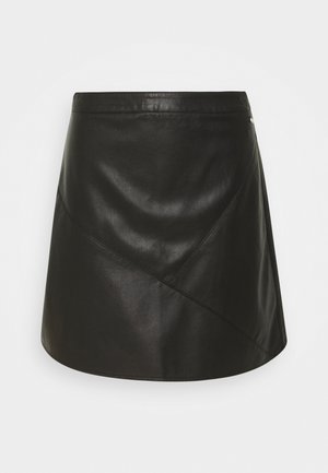 Jupe en cuir noir avec une taille cintrée, des coutures en biais, une texture lisse, et un léger évasement à l'ourlet. Détail métallique simple inclus.