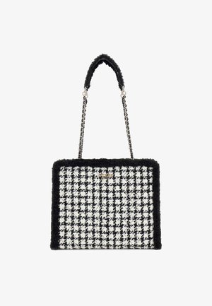 Sac à main en damier noir et blanc, avec une bordure texturée noire, une chaîne argentée et une forme rectangulaire structurée.