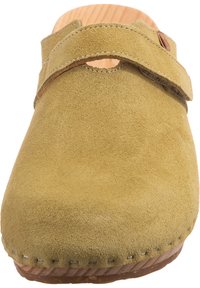 Gul mockaklack med trädsula, med ett brett band och cirkulär urtagning. Sömmen är synlig längs kanterna.