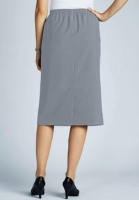 Grauer knielanger Rock mit elastischem Bund, glatter Textur und einfacher Schnitt. Getragen mit schwarzen High Heels.