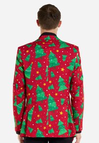 Rode blazer met een kerstboompatroon in groen,accenten met sterren en witte stippen, met een zwarte revers en knoopdetails.