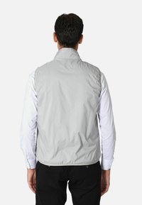 Gilet senza maniche grigio chiaro con colletto alto, realizzato in tessuto liscio e resistente all'acqua. Presenta un orlo elasticizzato e senza hardware visibile.