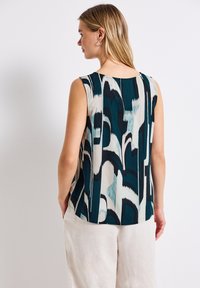 Top senza maniche con un motivo astratto in teal, beige e nero. Tessuto leggero con una vestibilità morbida e scollo rotondo.