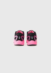 Chaussures de sport noires et roses avec un dessus en mesh, un talon rembourré et des accents roses distinctifs sur les côtés, comportant un détail de marque à l'arrière.