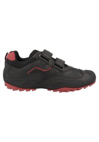 Chaussure de sport noire avec des accents rouges, dotée d'un dessus en synthétique, de panneaux texturés et de deux bandes auto-agrippantes. Semelle en caoutchouc rainurée.