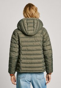 Gewatteerde olijfgroene jas met capuchon, voorzien van een doorgestikt ontwerp, elastische manchetten en een contrasterende binnenwristsdetail.