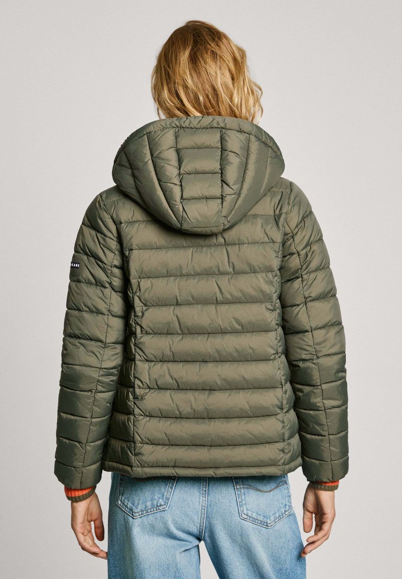 Veste rembourrée vert olive avec capuche, possédant un design matelassé, des poignets élastiques et un détail contrastant à l'intérieur des poignets.