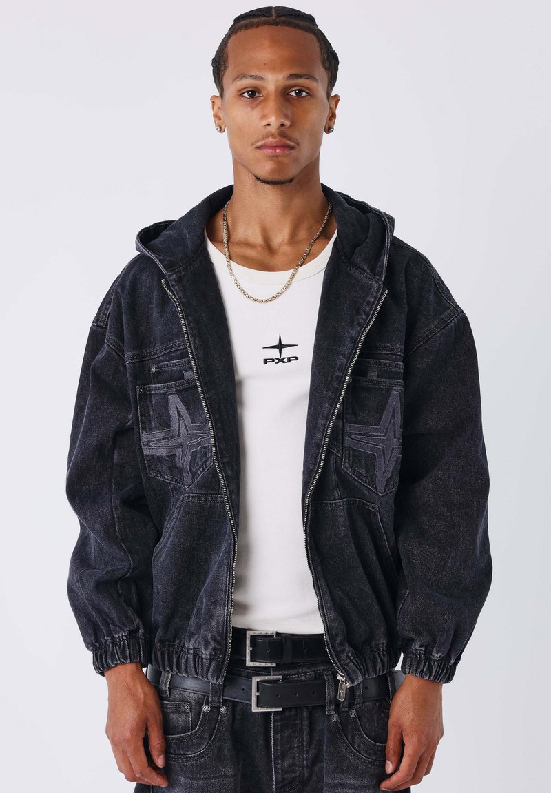 Zwarte mannen denimjas met capuchon, elastische manchetten en stervormige accenten; gedragen over een wit T-shirt met het "PXP"-logo.