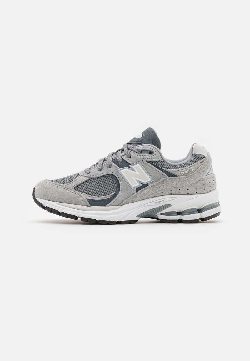 Baskets New Balance 2002R grises avec tige en suède et mesh, semelle intermédiaire blanche et semelle extérieure noire, présentées sur fond blanc.